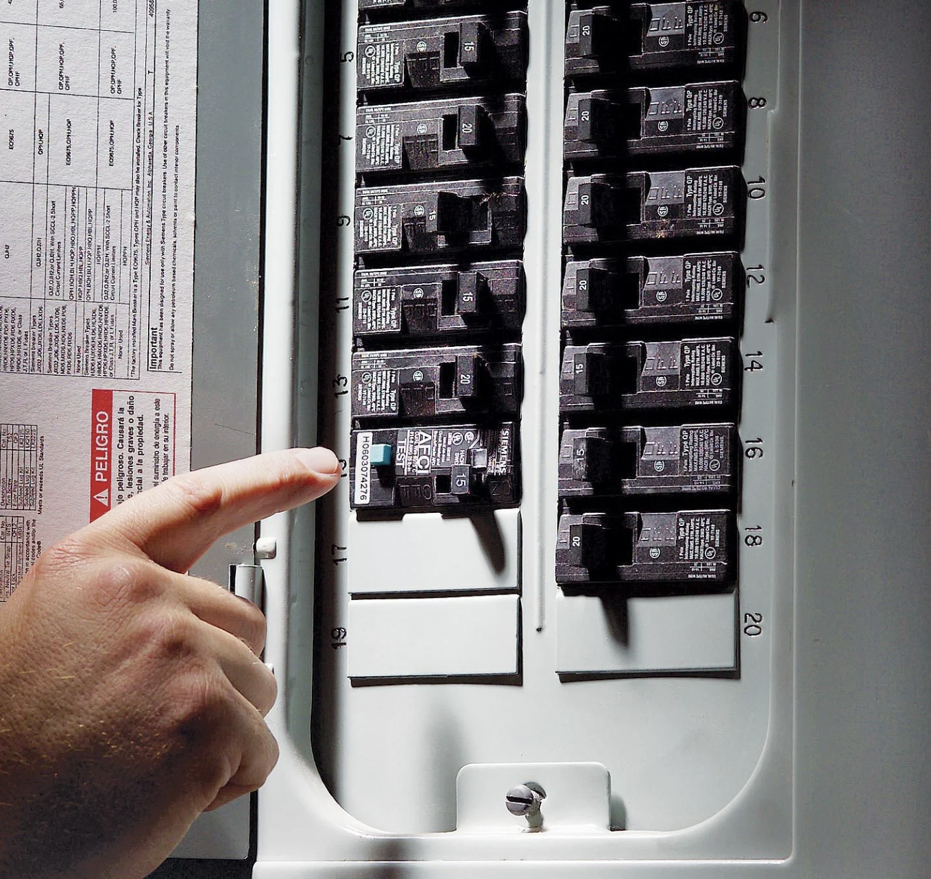 Electrical breaker box with labeled circuit breakers inside an open panel
